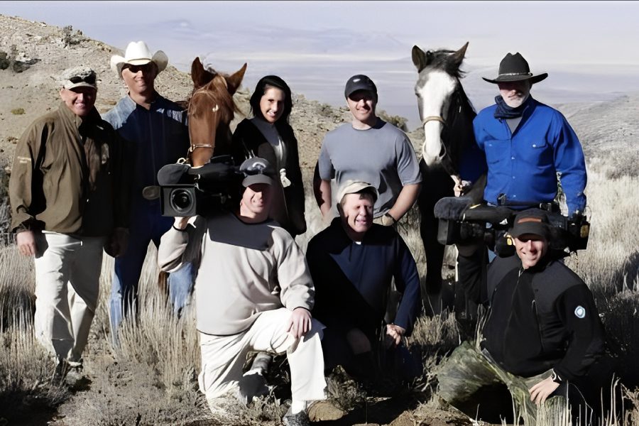Group of people and horses outdoors.