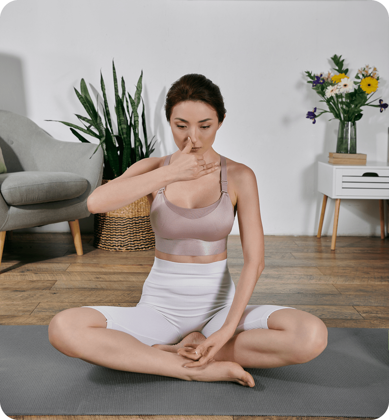 Woman practicing yoga breathing exercise indoors.