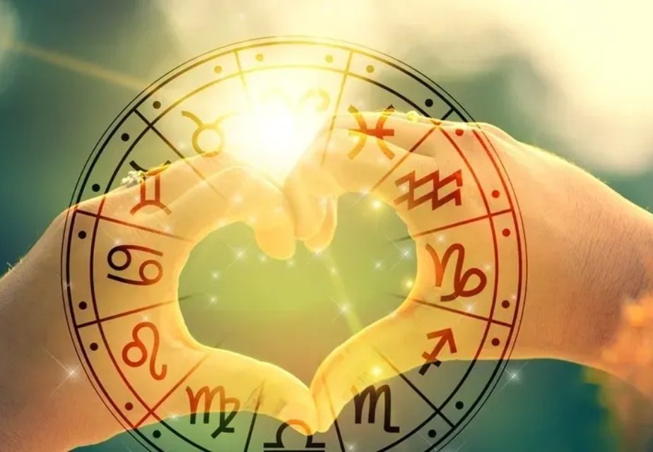 Hands forming heart with zodiac symbols overlay.