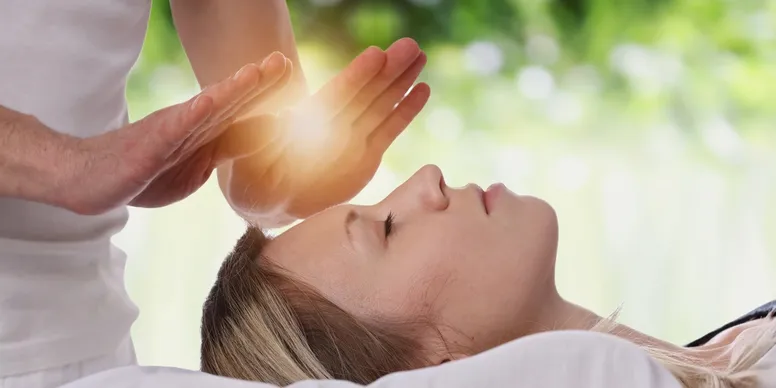 A person receiving a calming energy healing session outdoors.