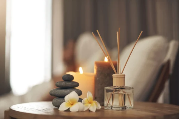 A serene spa setup with candles, incense sticks, and flowers.