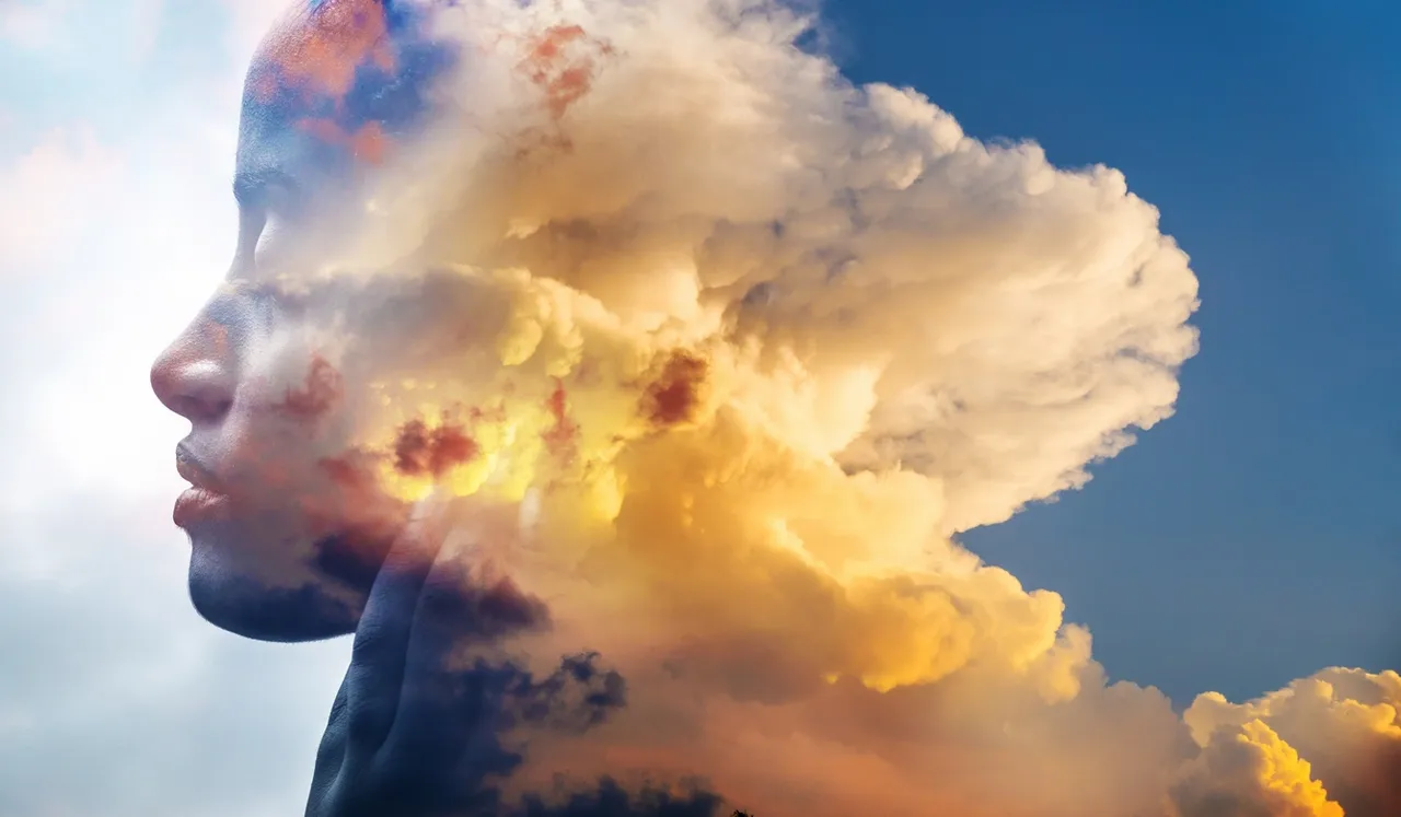 A towering cloud illuminated by golden sunlight against a blue sky.