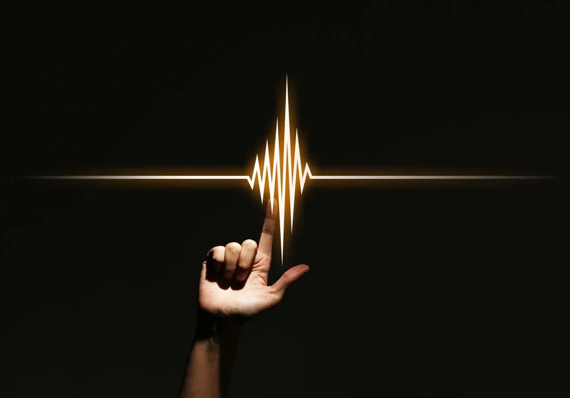A hand forms an L shape with a glowing heartbeat line above it.